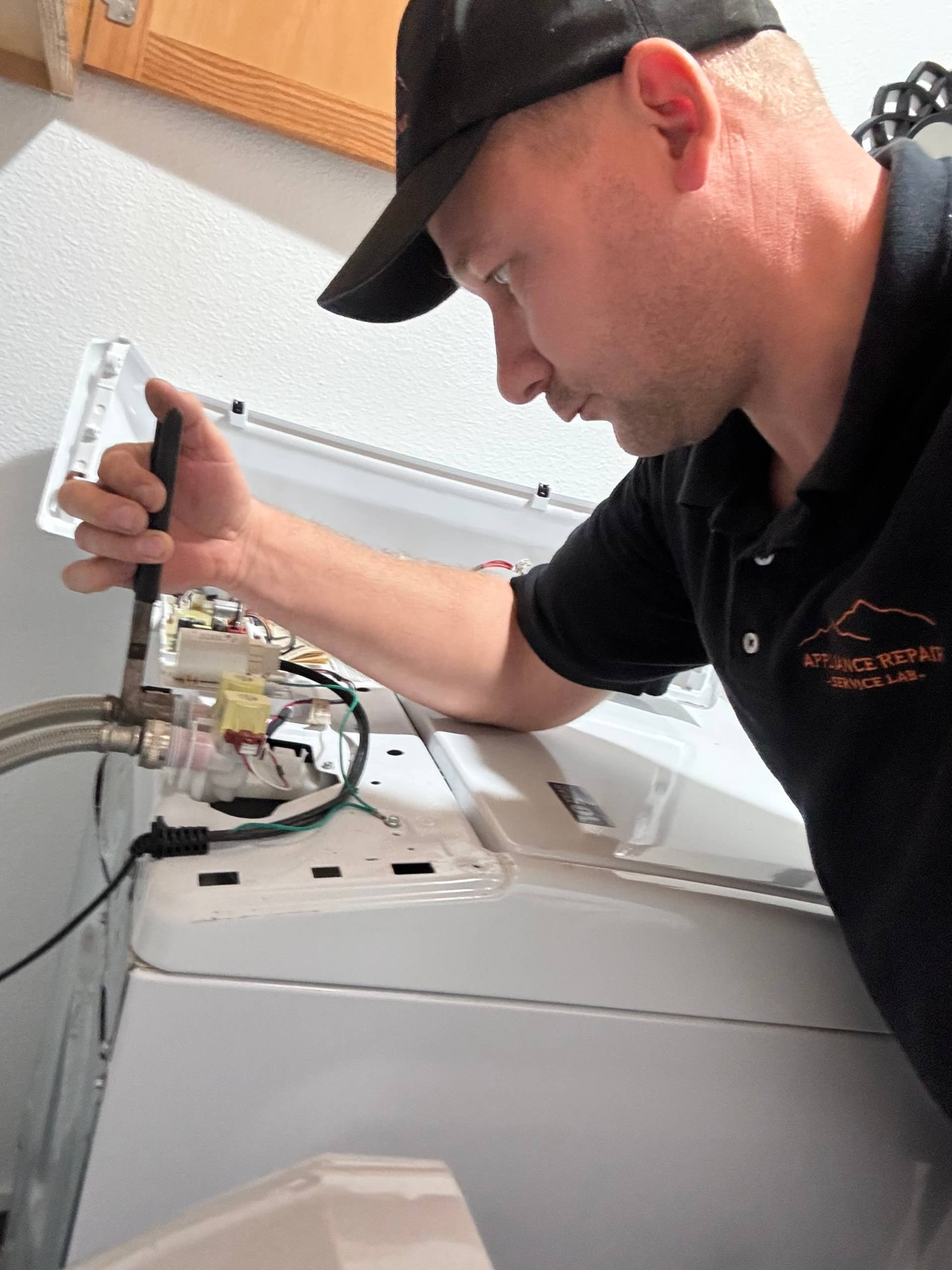 Technician replacing water inlet valve on Maytag top-load washer in Portland, OR