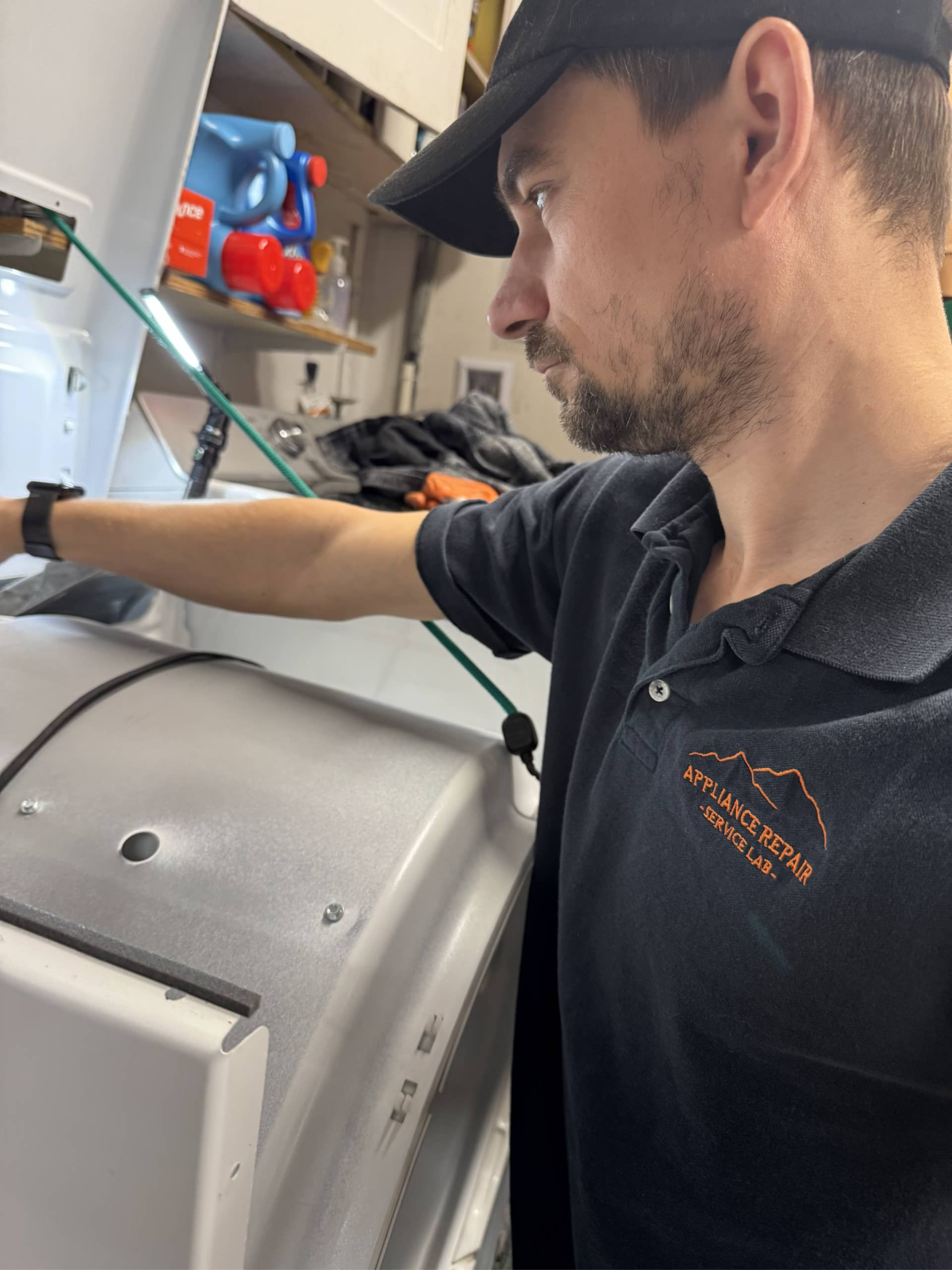 appliance repair technician inspecting dryer drum and internal components