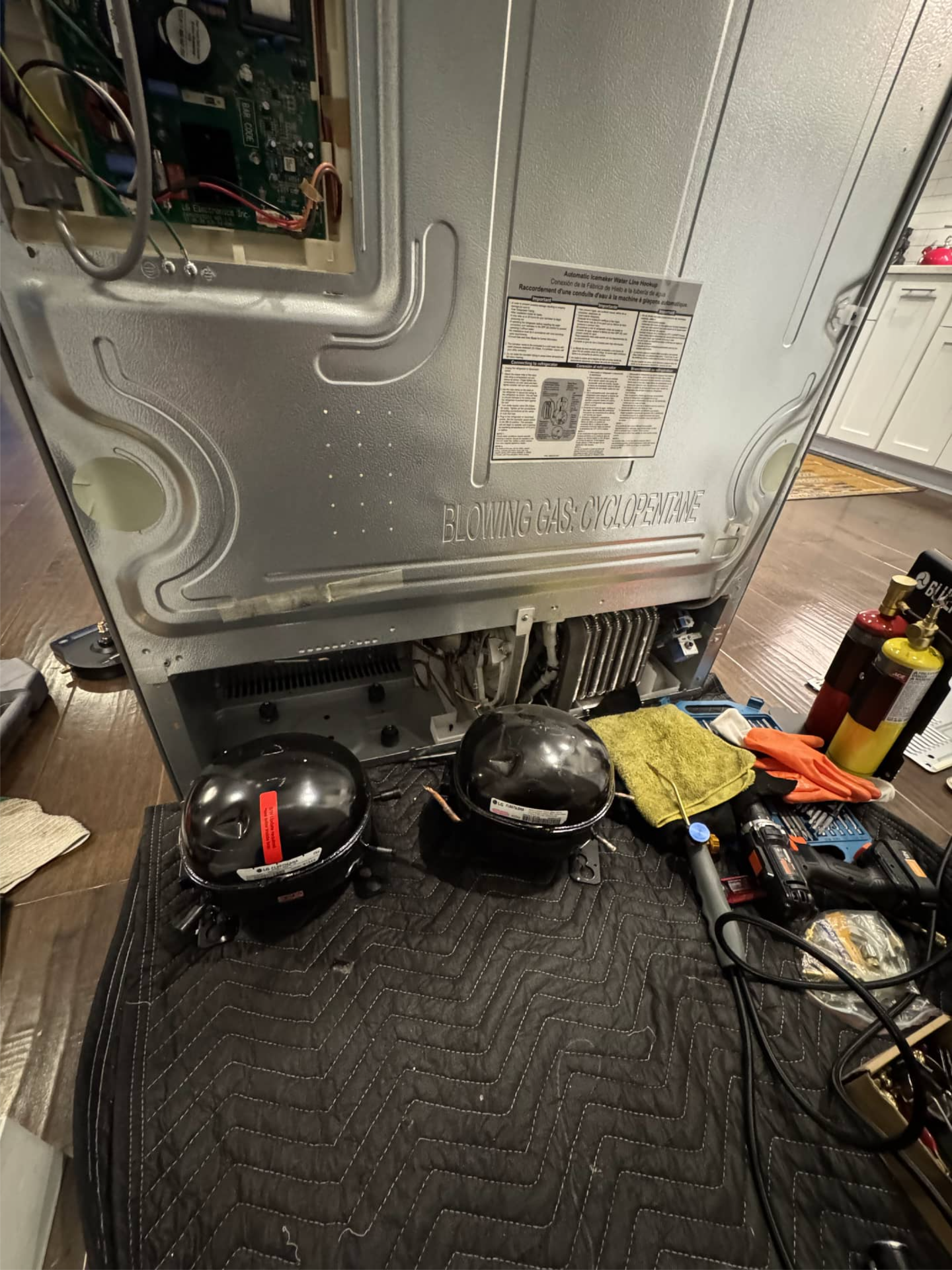 LG refrigerator with old and replacement compressors during repair in Happy Valley, OR 97086